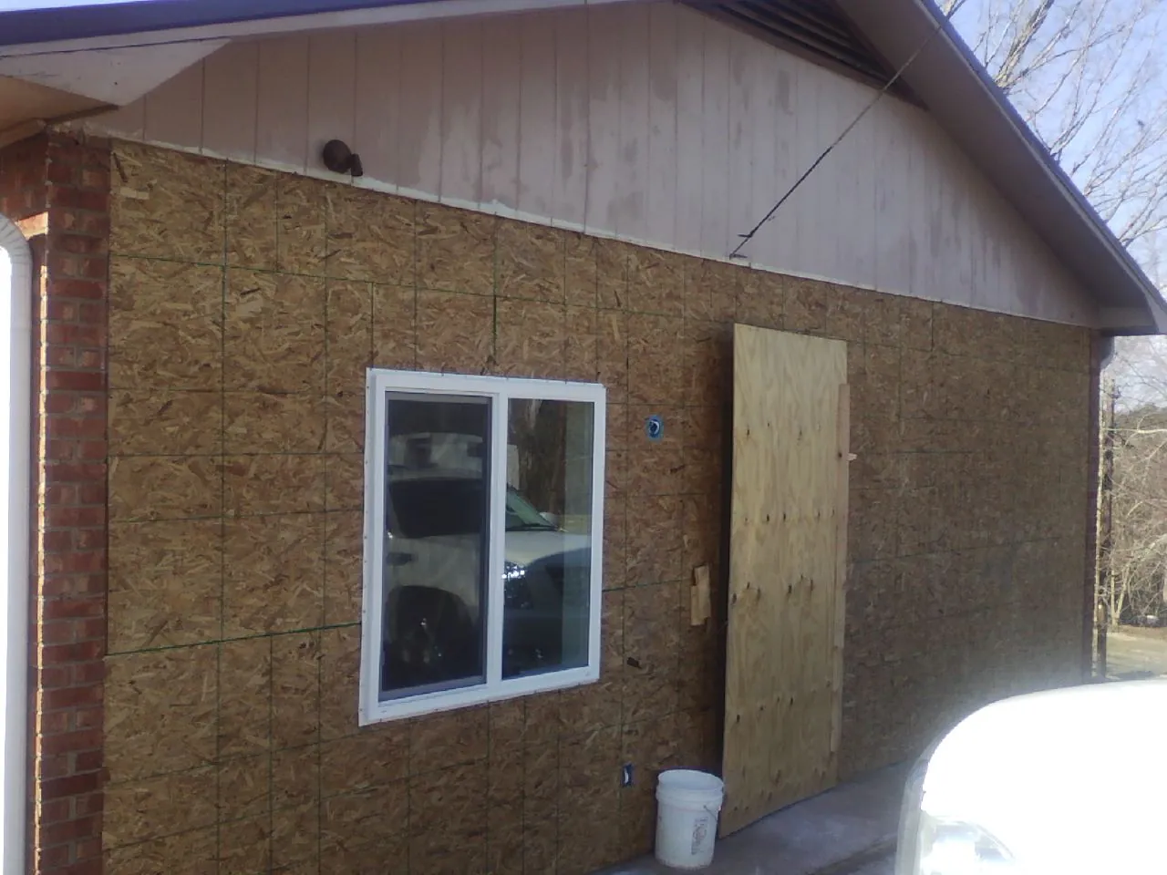 OSB sheathing on a garage addition wall before siding in Portage